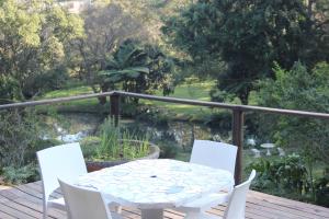 a white table and chairs on a deck with a pond at One on Old Main Unit 8 in Hillcrest +9 photos