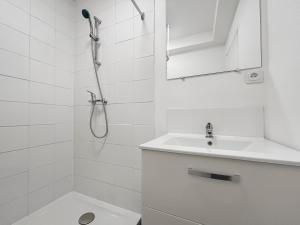 une salle de bain blanche avec une douche et un lavabo dans l'établissement CarlAppartement Elegance et Confort avec Wi-Fi & Parking II, à Carling