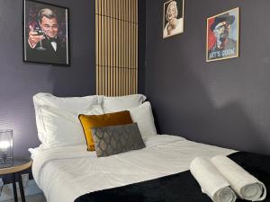 a bed in a room with posters on the wall at L'icône du cinéma - Studio cosy - Gare - Centre-ville Evreux - Wifi in Évreux