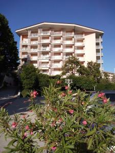 - un grand immeuble avec des fleurs devant dans l'établissement Central Residence, à Portorož