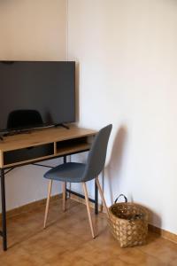 a desk with a television and a chair in a room at Villa Marina in Posidhonía +15 photos