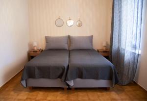 a bed in a bedroom with two lamps and a window at Villa Marina in Posidhonía