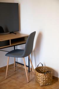 a chair sitting next to a desk with a television at Villa Marina in Posidhonía