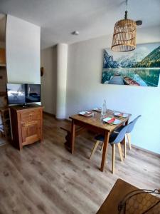 a dining room with a table and a tv at Appartement T2 Vue montagne in Cauterets