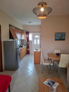 a kitchen and dining room with a table and a refrigerator at Rousela apartment in Vasilikos +6 photos
