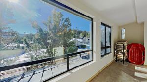 a room with a large window with a red chair in front at Retro 3 Bed 3 Bath Condo with Mountain View! Steps to Canyon Lodge! Unit 210 at 1849 in Mammoth Lakes