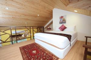 a bedroom with a white bed and a wooden ceiling at 328包棟民宿 獨棟小木屋 in Luodong