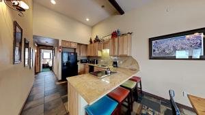 a kitchen with a sink and a counter with stools at Beautifully Remodeled 4 Bedroom Condo in Mammoth Lakes +47 photos