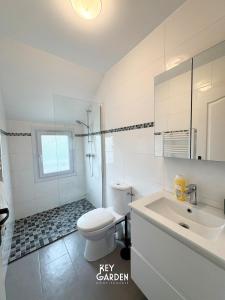 a white bathroom with a toilet and a sink at Maison calme 10 min from Disneyland in Villiers-sur-Morin