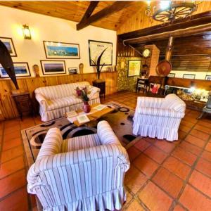 a living room with two couches and a table at Pousada das Montanhas - Monte Verde in Monte Verde