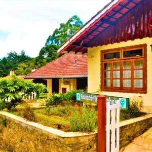 a house with a street sign in front of it at Pousada das Montanhas - Monte Verde in Monte Verde