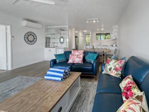 a living room with a blue couch and a table at Beach Lodges Premium in Hamilton Island