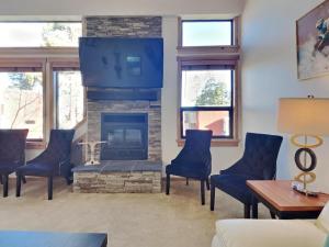 a living room with a fireplace and blue chairs at Spacious 3 BR Condo with Loft in Mammoth Lakes