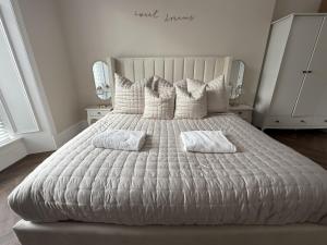 a bedroom with a white bed with two pillows at Murraygate Townhouse in Dundee