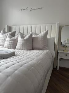 a white bed with pillows on it in a bedroom at Murraygate Townhouse in Dundee