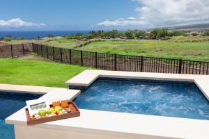 a swimming pool with a bowl of fruit and a tray of juice at HOKU LANI HOUSE Heated Private Pool Spa Intro Pricing 25% off in Waimea