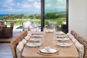 a wooden table with plates and wine glasses on a patio at HOKU LANI HOUSE Heated Private Pool Spa Intro Pricing 25% off in Waimea