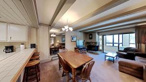 a kitchen and living room with a wooden table in a room at Beautiful 2 BR Condo with Mountain View! in Mammoth Lakes