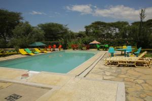 una piscina con sedie e tavoli colorati di Adeea Suites Naivasha a Naivasha