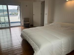 una camera da letto con un letto bianco e un balcone di Casa Flor de Lis a Cee Altre 12 foto