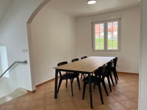 un tavolo da pranzo con sedie nere e una finestra di Casa Flor de Lis a Cee