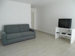 a living room with a couch and a tv at Casinha do Mar in Carvide