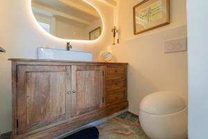 a bathroom with a wooden vanity and a sink at L'hôtel des oiseaux in Les Baux-de-Provence