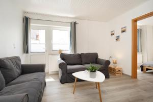 a living room with a couch and a table at Gästehaus Sulsdorf Wohnung 18 in Sulsdorf auf Fehmarn