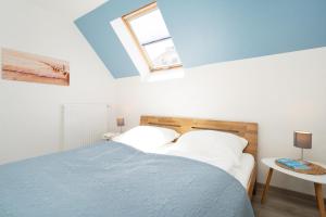 a bedroom with a blue bed and a window at Gästehaus Sulsdorf Wohnung 18 in Sulsdorf auf Fehmarn