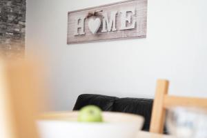 a living room with a couch and a sign that reads love at Gästehaus Sulsdorf Wohnung 9 in Sulsdorf auf Fehmarn