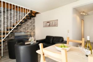 a living room with a table and chairs and a staircase at Gästehaus Sulsdorf Wohnung 9 in Sulsdorf auf Fehmarn