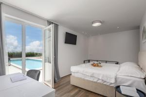 Villa Ivona di San Lorenzo Private Pool - Happy Rentals في Sveti Lovreč Pazenatički: غرفة نوم مع سرير وبلكونة مع مسبح