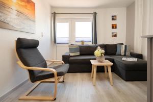 a living room with a couch and a chair at Gästehaus Sulsdorf Wohnung 20 in Sulsdorf auf Fehmarn
