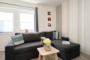 a living room with a black couch and a table at Gästehaus Sulsdorf Wohnung 20 in Sulsdorf auf Fehmarn +30 photos