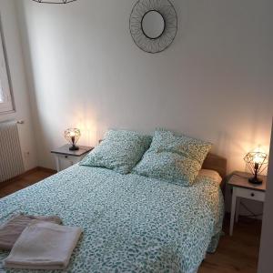 Un dormitorio con una cama con edredón azul y dos lámparas. en Le sourire de Mona Lisa 2 étoiles 100m du château, en Amboise