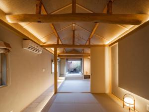 名古屋貸切宿KIKUNOYA-hakuga-名古屋駅新幹線口より徒歩10分的带有木质天花板的建筑物的走廊