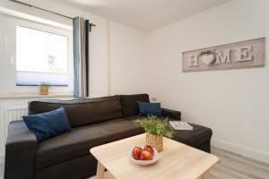 a living room with a couch and a table with a bowl of fruit at Gästehaus Sulsdorf Wohnung 15 in Sulsdorf auf Fehmarn