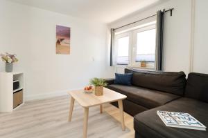 a living room with a couch and a table at Gästehaus Sulsdorf Wohnung 15 in Sulsdorf auf Fehmarn