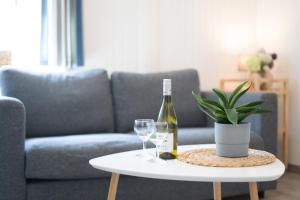a bottle of wine and glasses on a table in a living room at Gästehaus Sulsdorf Wohnung 16 in Sulsdorf auf Fehmarn