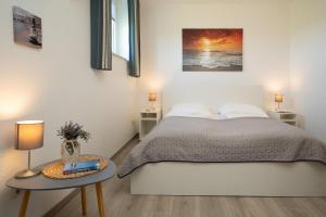 a bedroom with a bed and two tables with lamps at Gästehaus Sulsdorf Wohnung 8 in Sulsdorf auf Fehmarn