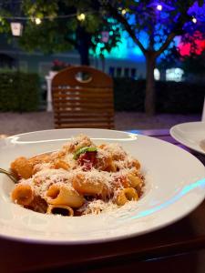 a plate of pasta with cheese on a table at La Veneziana Guesthouse in Aschach an der Donau