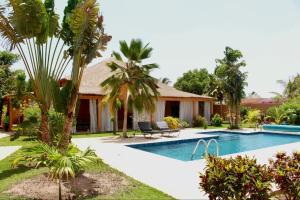 a villa with a swimming pool and a resort at Villa Épuré Tribale in Darou Rhamane