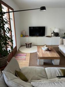 een woonkamer met een bank en een tafel bij Grande maison familiale Leucate Village in Leucate