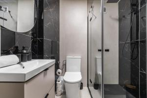 a bathroom with a toilet and a sink and a shower at Summer5 by Grand Apartments in Gdańsk