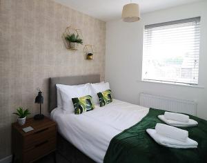 a bedroom with a bed with white sheets and pillows at 2 Bed Semi House - Driveway Parking in Lancaster