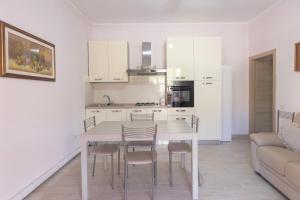 une cuisine avec une table, des chaises et un canapé dans l'établissement Il Giardino di Rio - HelloElba, à Rio Marina