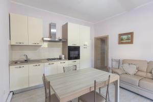 une cuisine et un salon avec une table et un canapé dans l'établissement Il Giardino di Rio - HelloElba, à Rio Marina