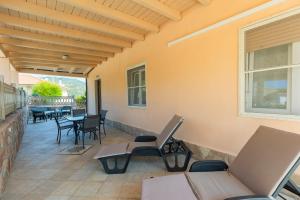 a patio with chairs and tables and a window at Il Giardino di Rio - HelloElba in Rio Marina +15 photos