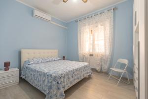 - une chambre bleue avec un lit et une chaise dans l'établissement Il Giardino di Rio - HelloElba, à Rio Marina 16 autres photos