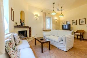 a living room with two white couches and a fireplace at Luxury Villa Flaminia, 50 mt from the beach in Santa Margherita di Pula